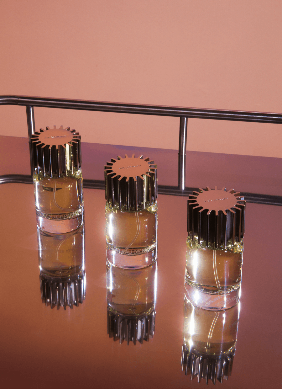 three glass fragrance bottles in a diagonal line