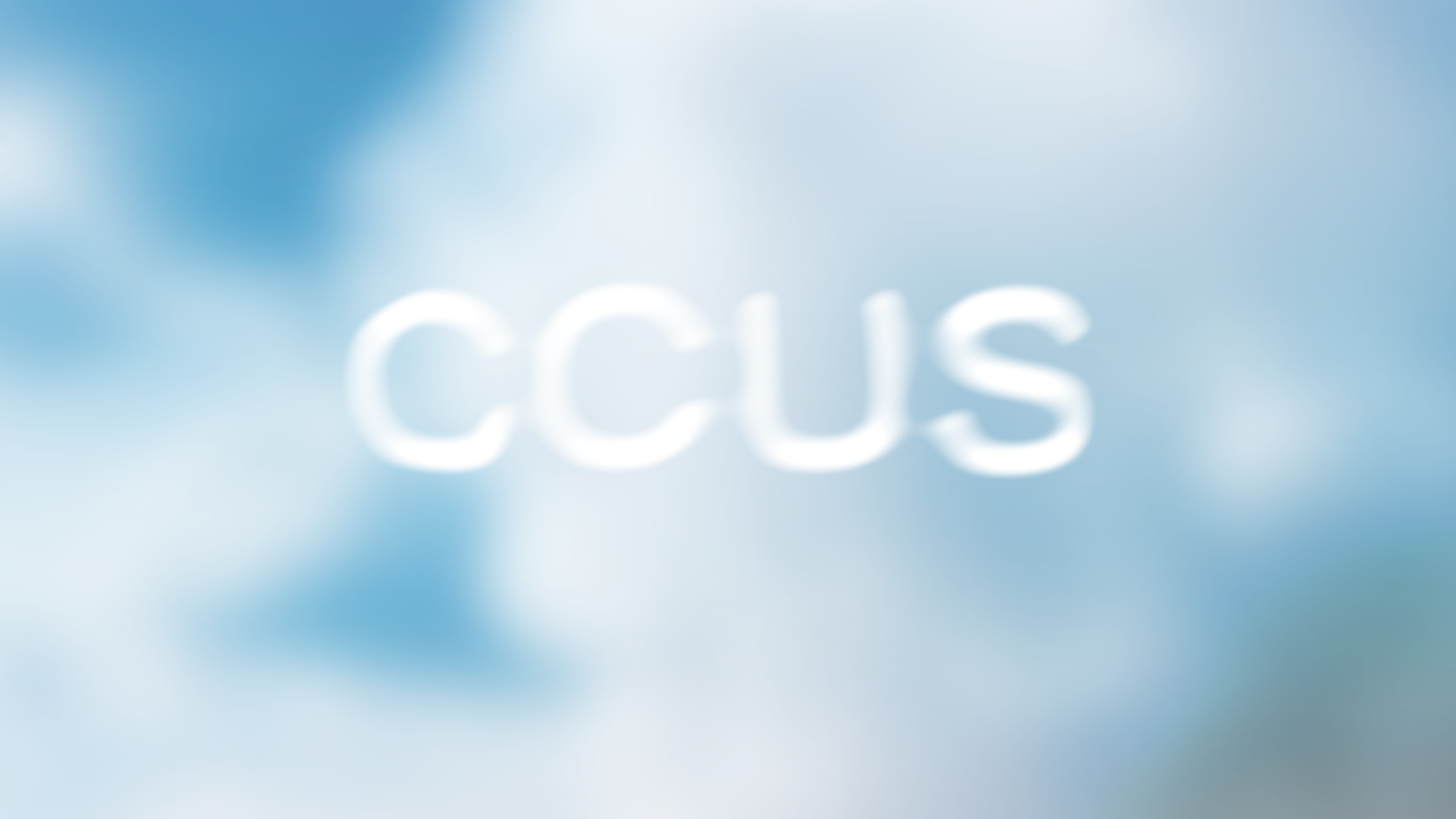 The word "CCUS" in blurry white text against a soft, cloudy blue background.
