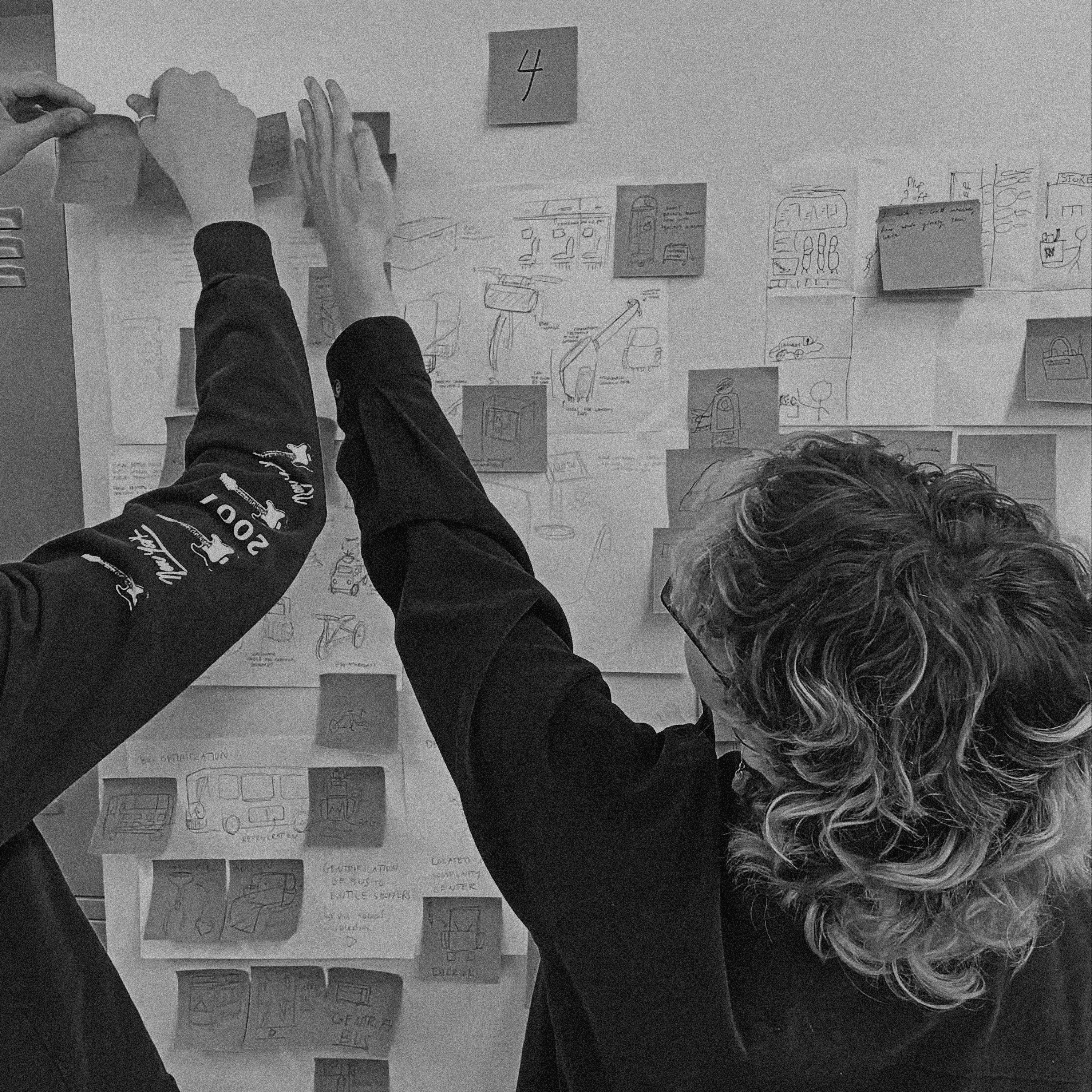 Students collaborating around a wall of notes
