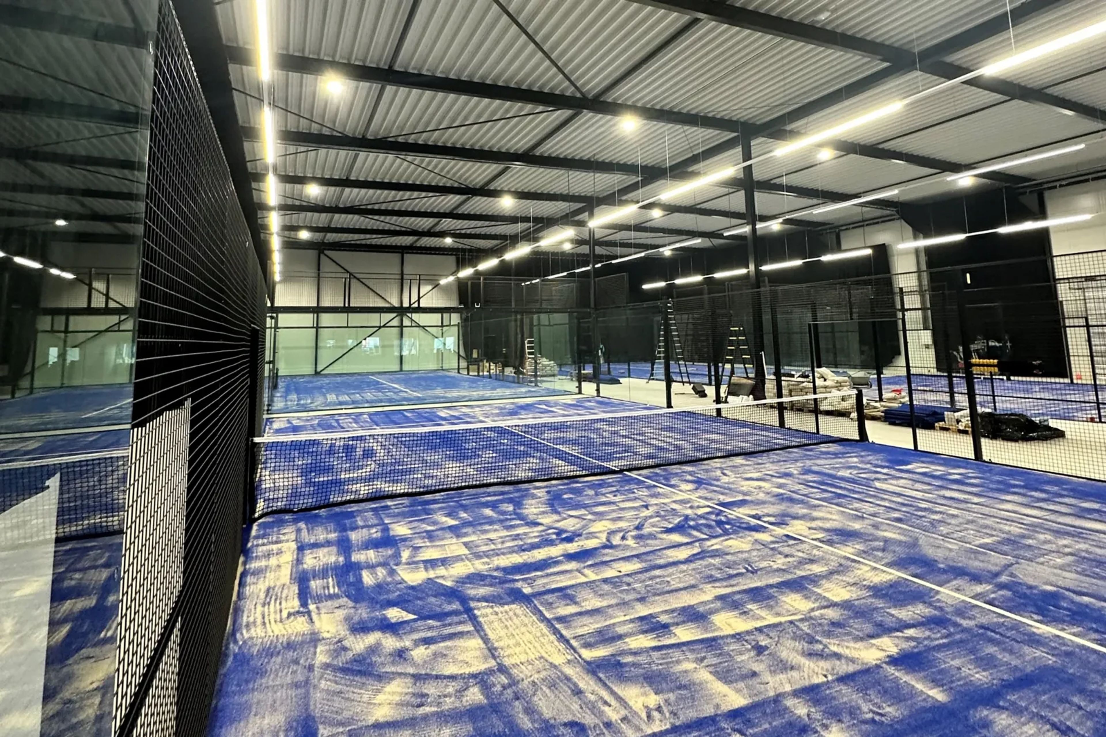 Wat is het verschil in energieverbruik tussen conventionele verlichting en LED bij een indoor padelbaan?