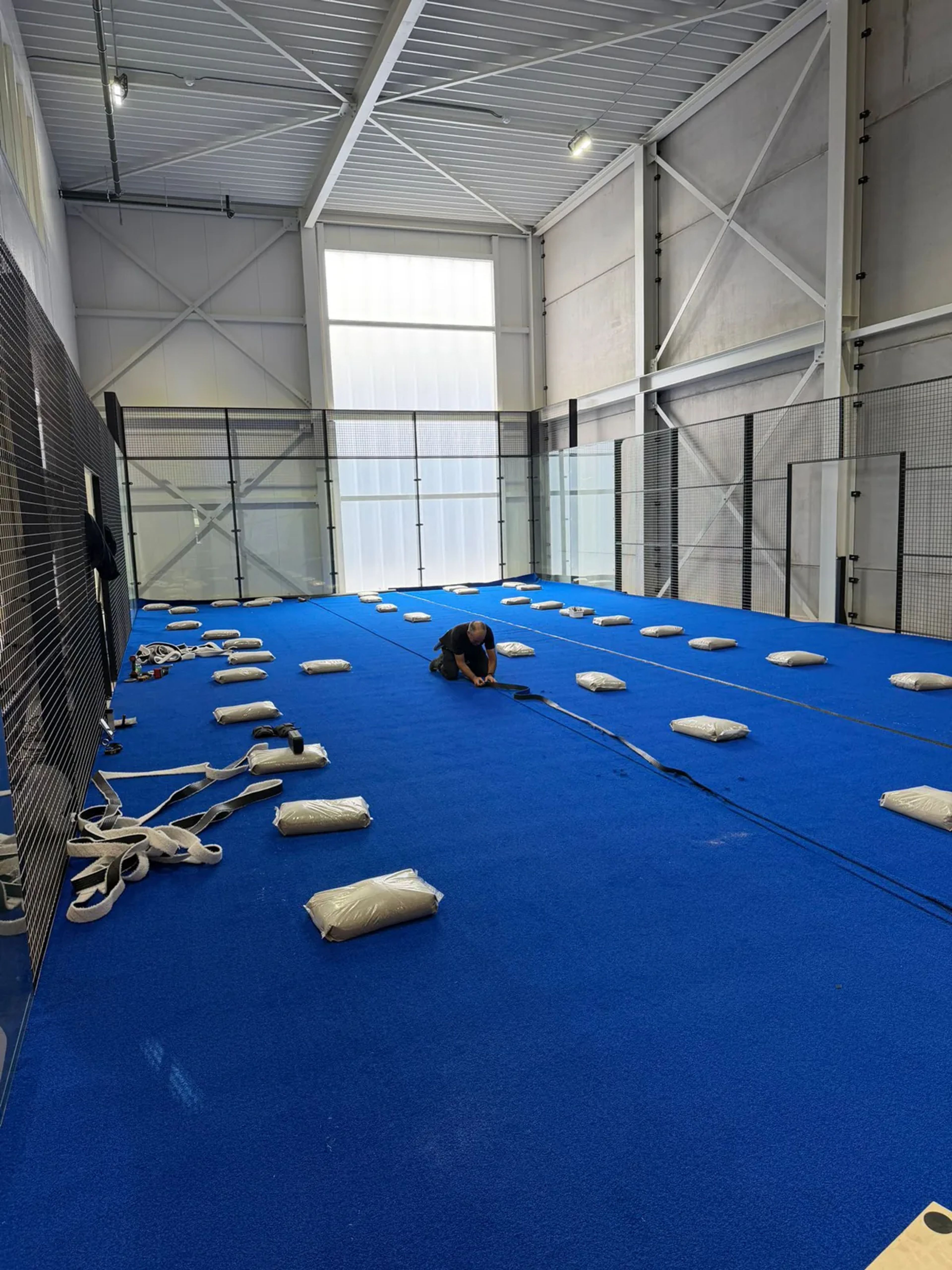 Aanleg van kunstgras met zandinstrooiing op een indoorbaan in Veldhoven