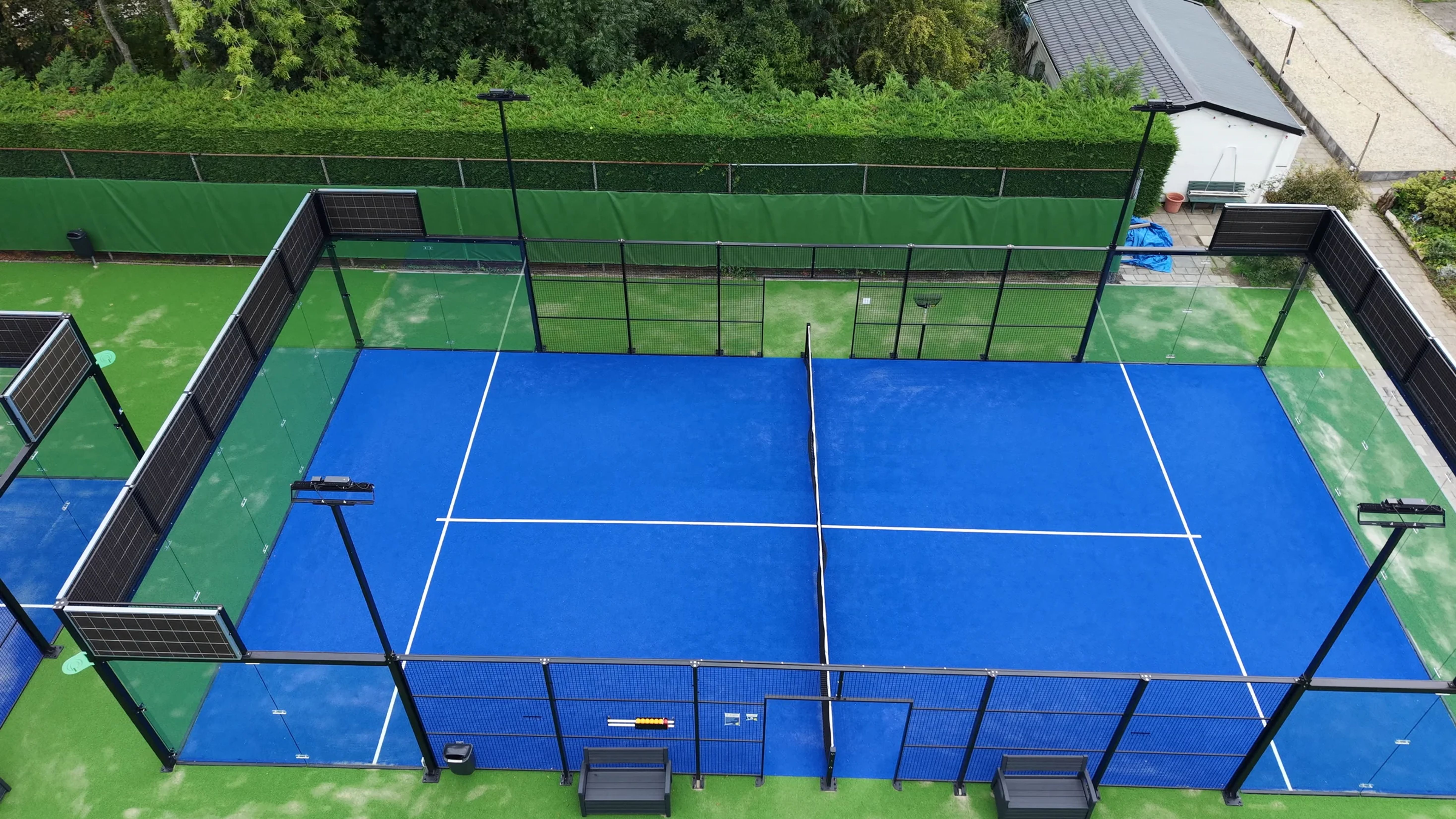 Dronebeeld van een outdoor panoramabaan van I-Padel met geluidsabsorberende panelen bij LTC Hofgeest in Velserbroek