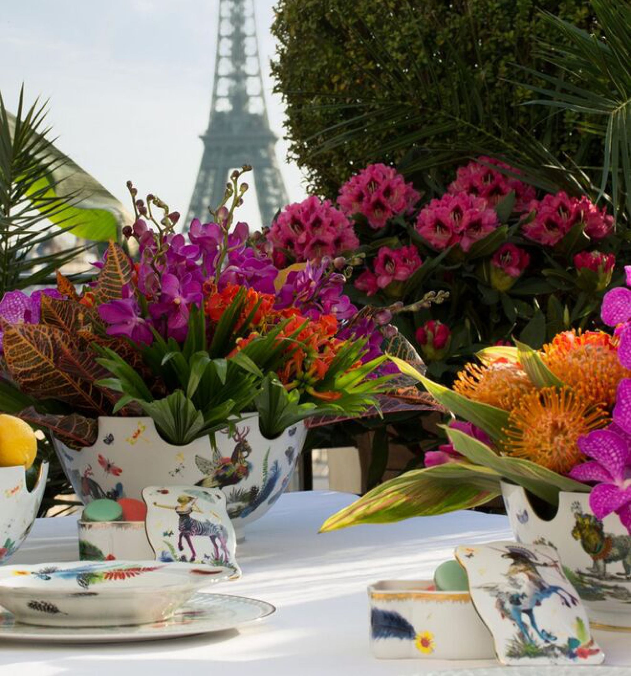 Virágokkal és mintás porcelánnal terített asztal az Eiffel-torony előtt