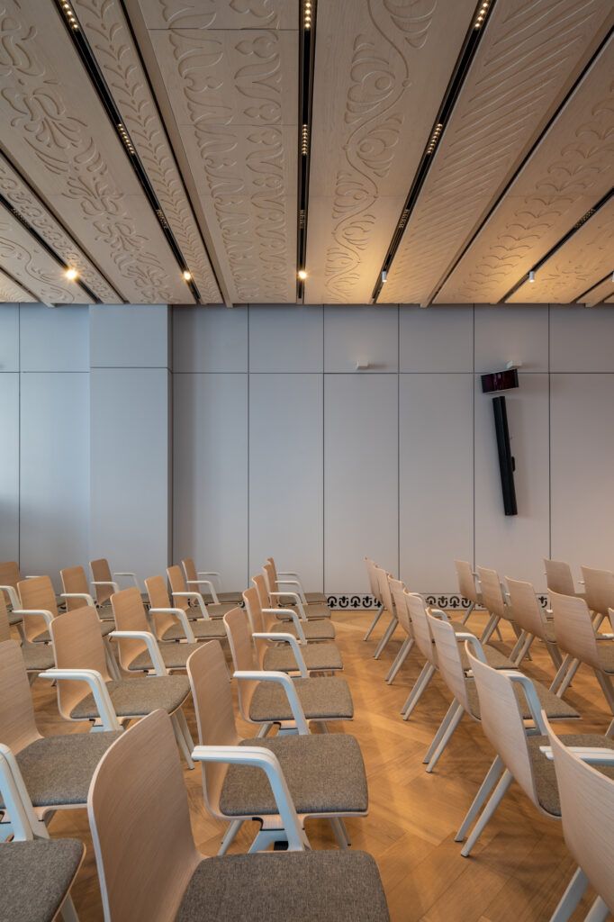 Konferenciaterem székekkel és bordázott mennyezettel
