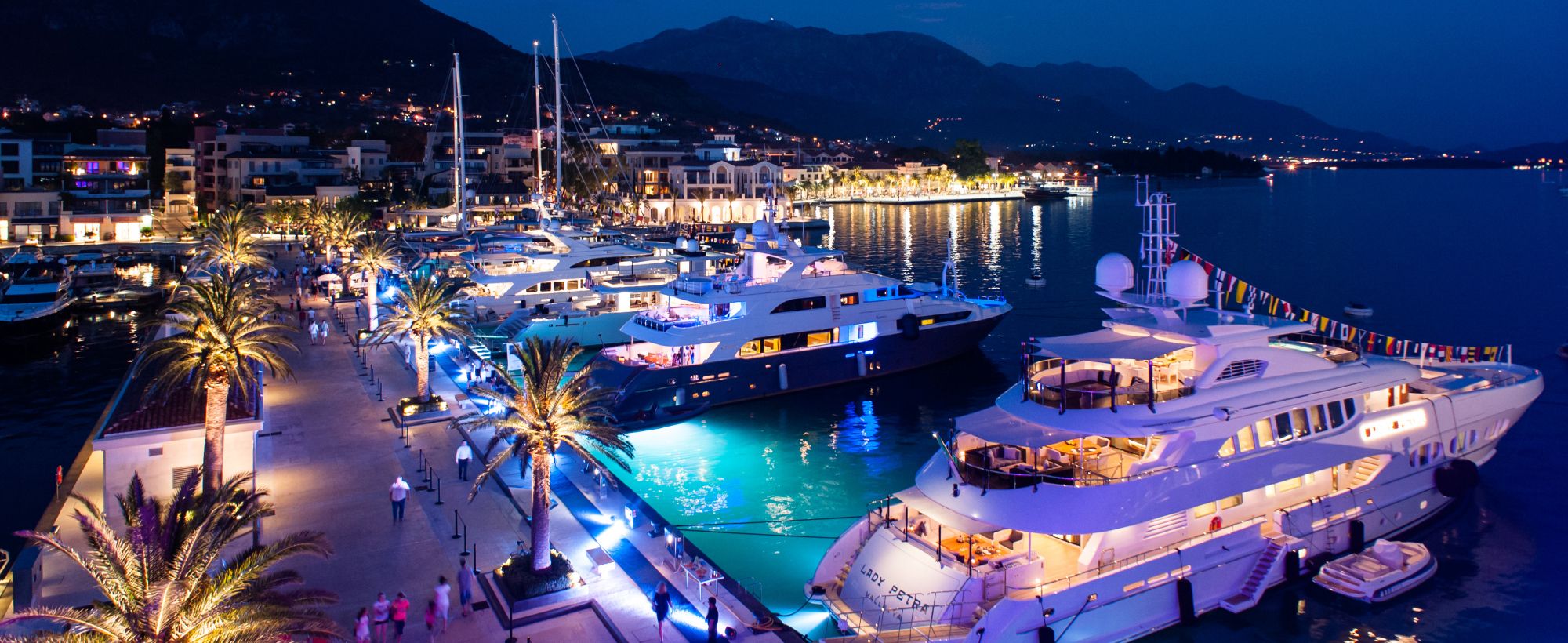 Kivilágított luxusjachtok a tivati Porto Montenegro kikötőjében éjszaka