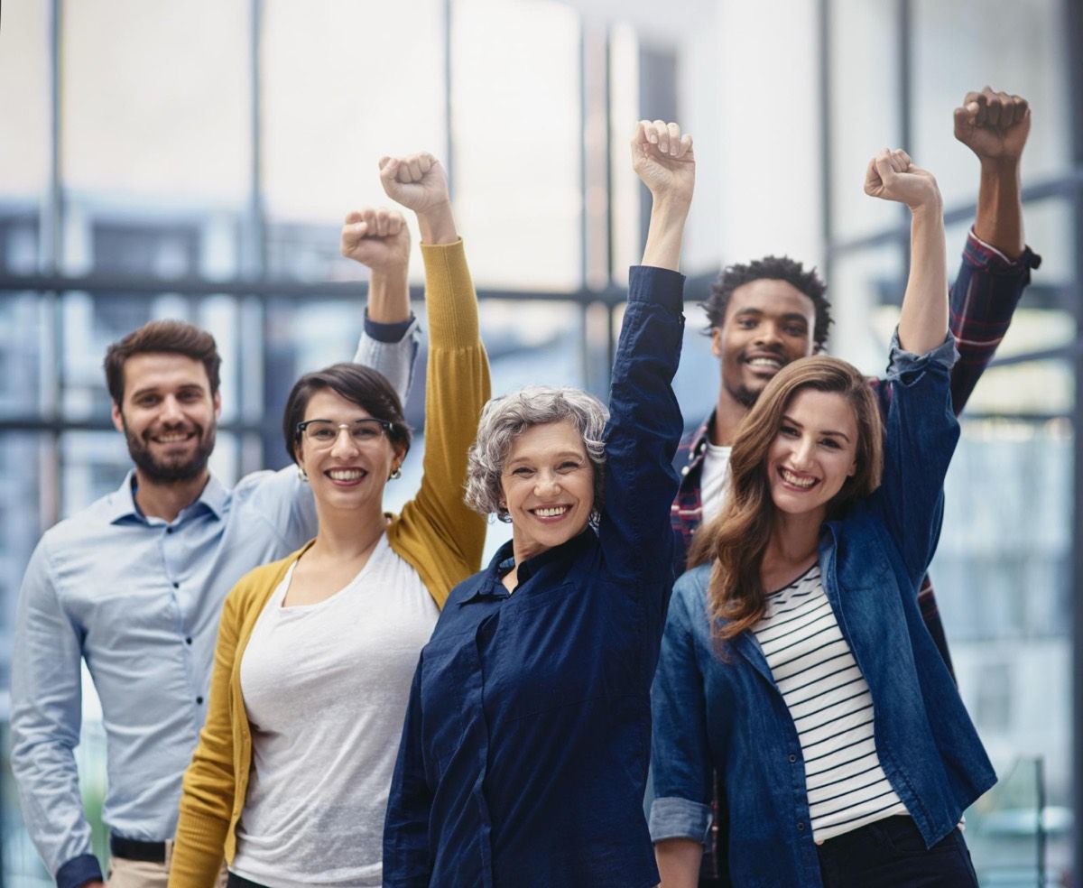 A team celebrating together with raised arms.