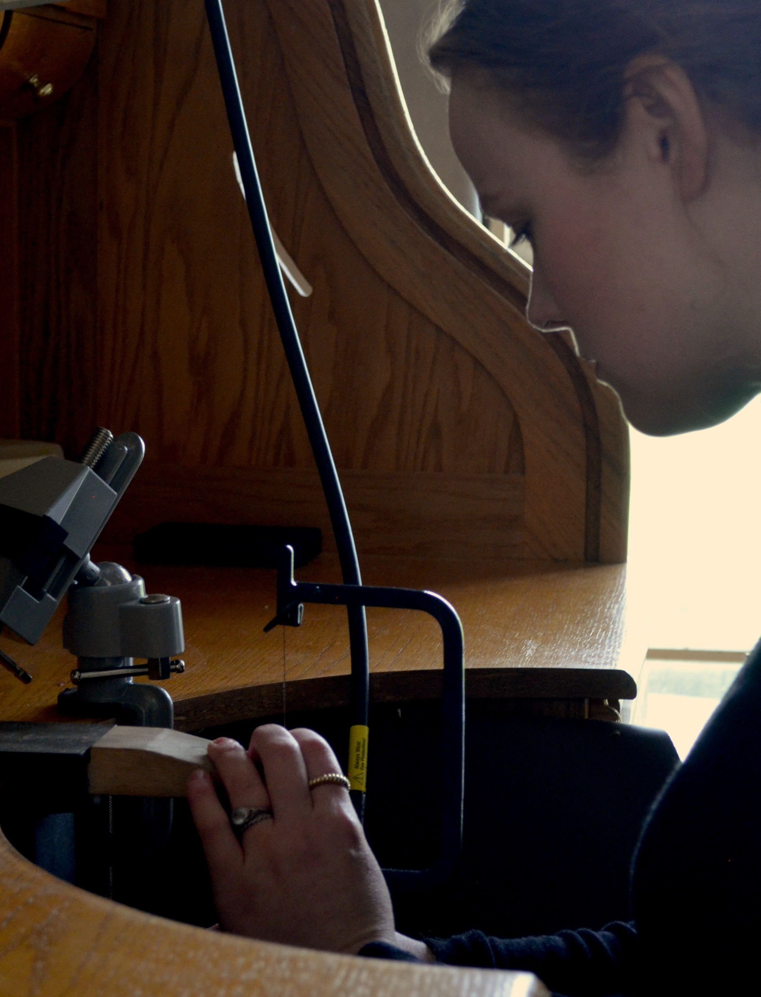 A woman, Laura, works on a ring at a work bench