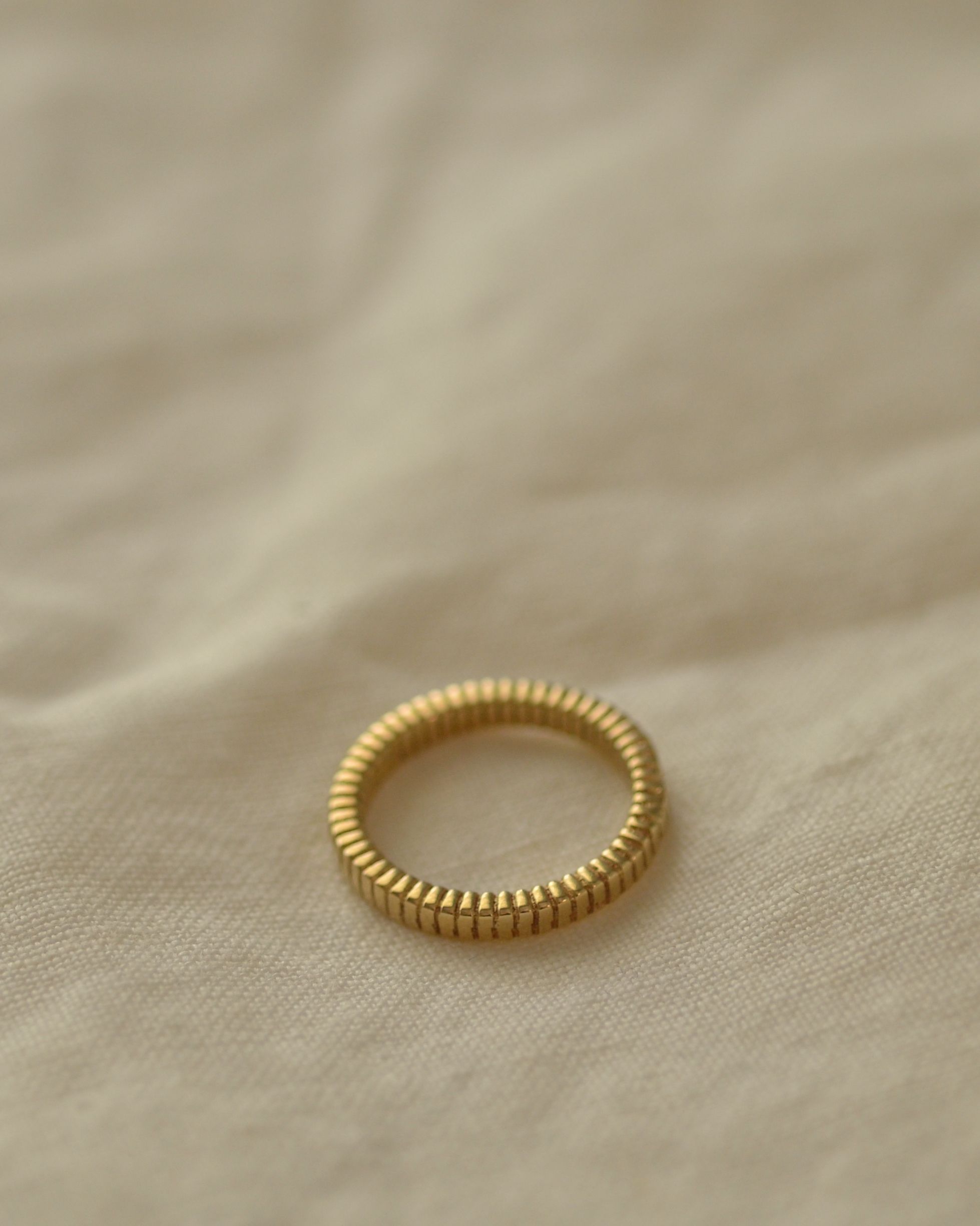 Solid gold fluted ribbed ring texture handmade on cream linen