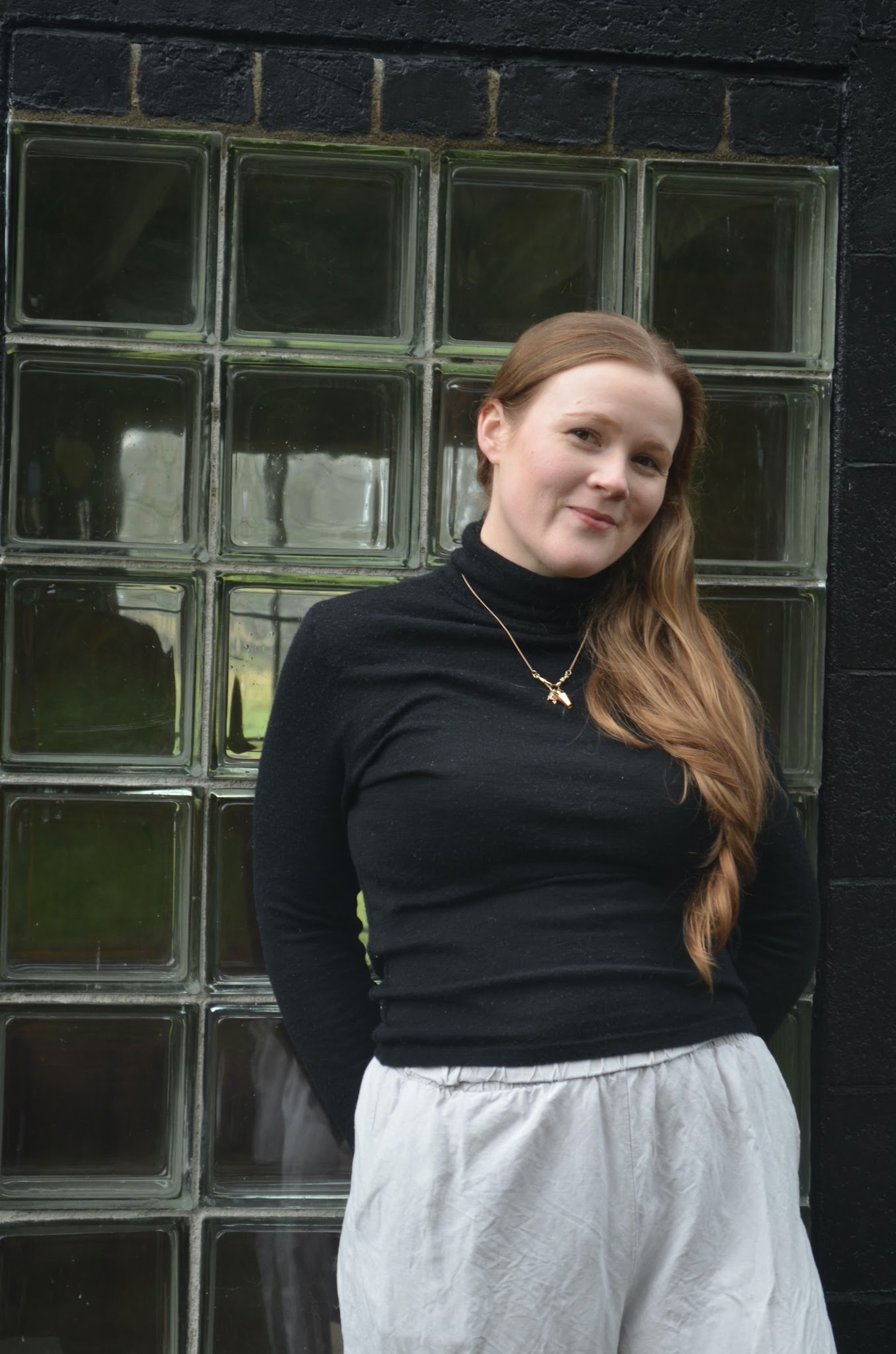 A woman, Laura Ward, standing in front of some glass bricks