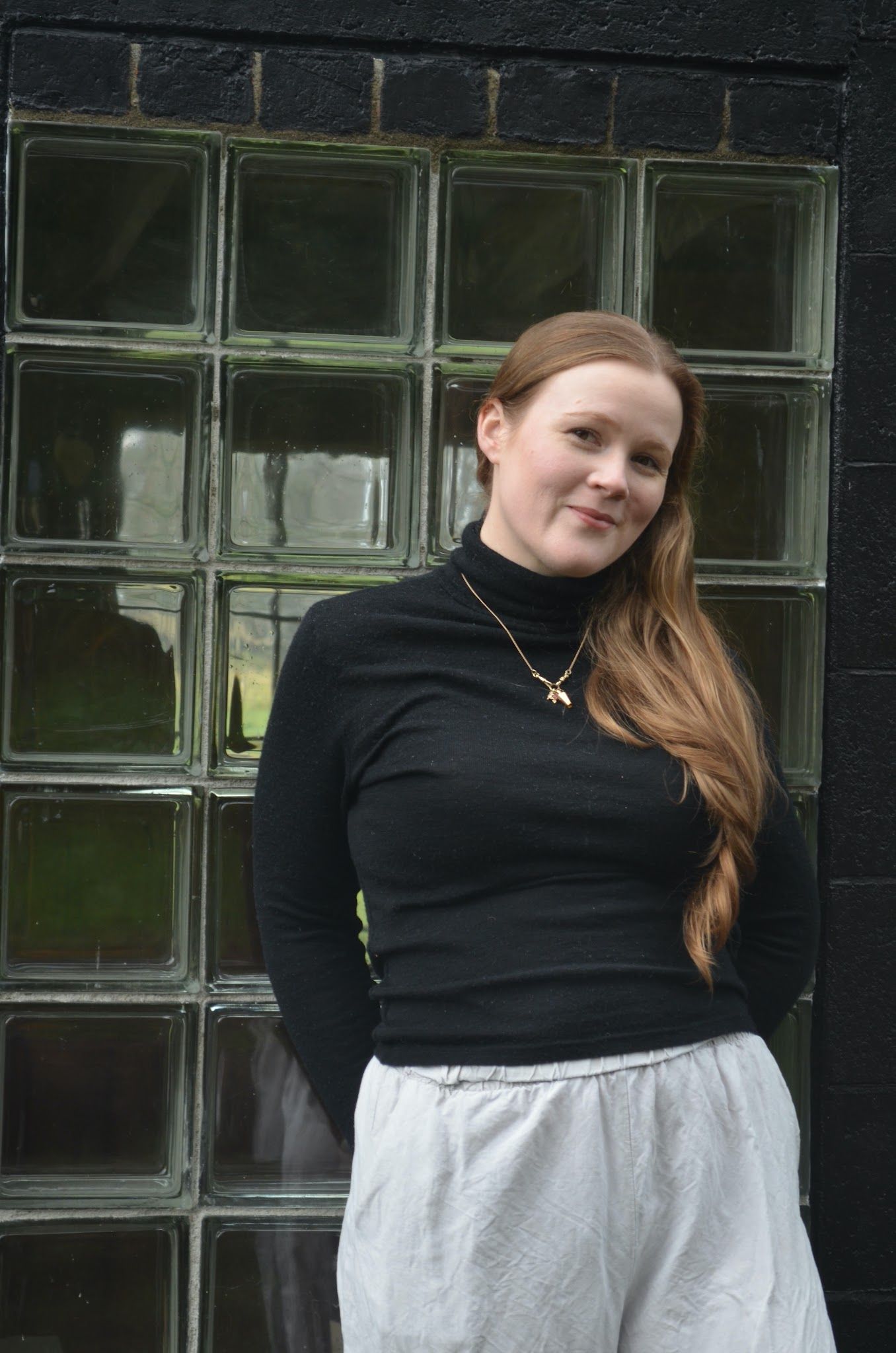 A woman, Laura Ward, standing in front of some glass bricks