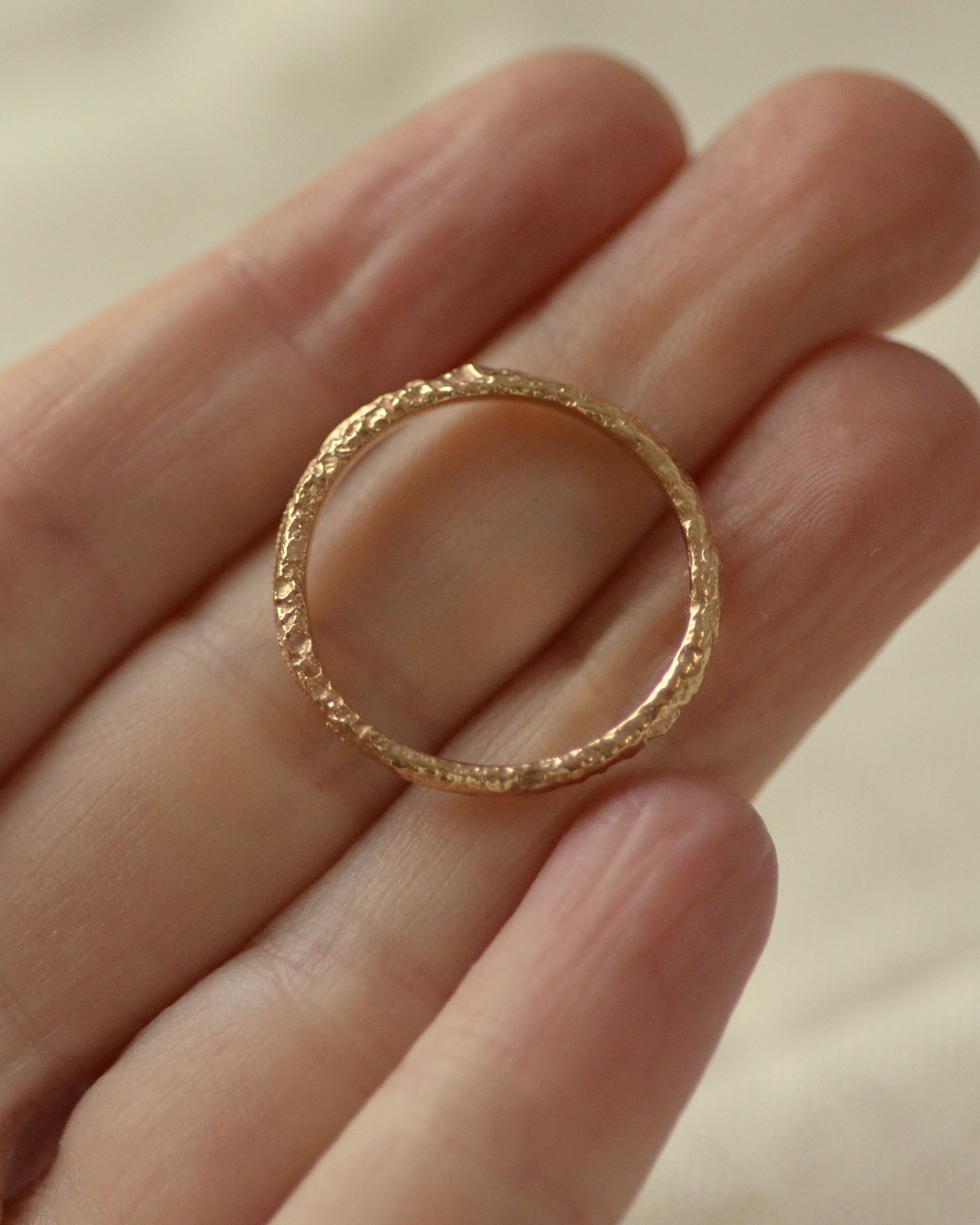 Textural salt gold ring held in hand 