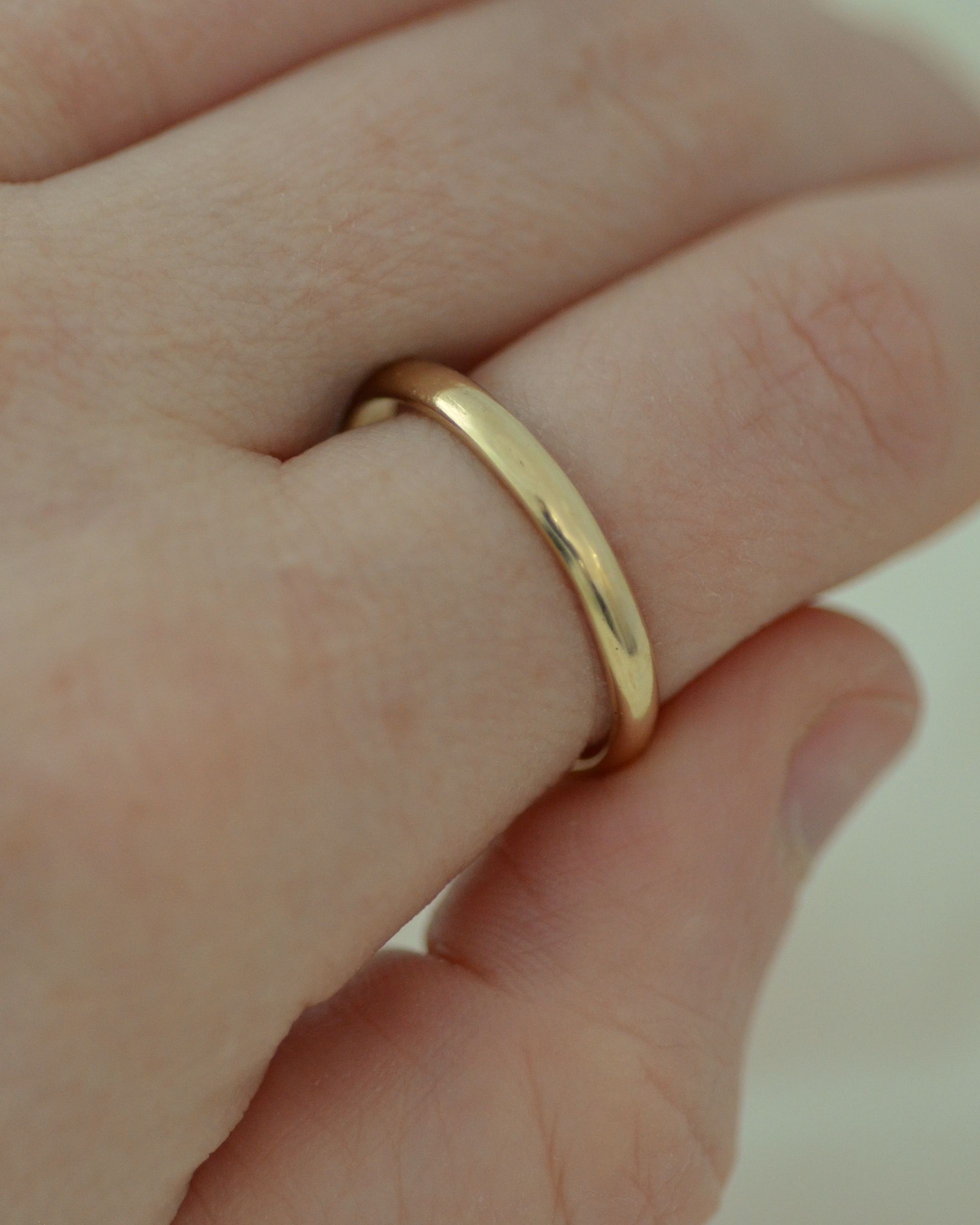 Smooth solid gold ring worn on finger