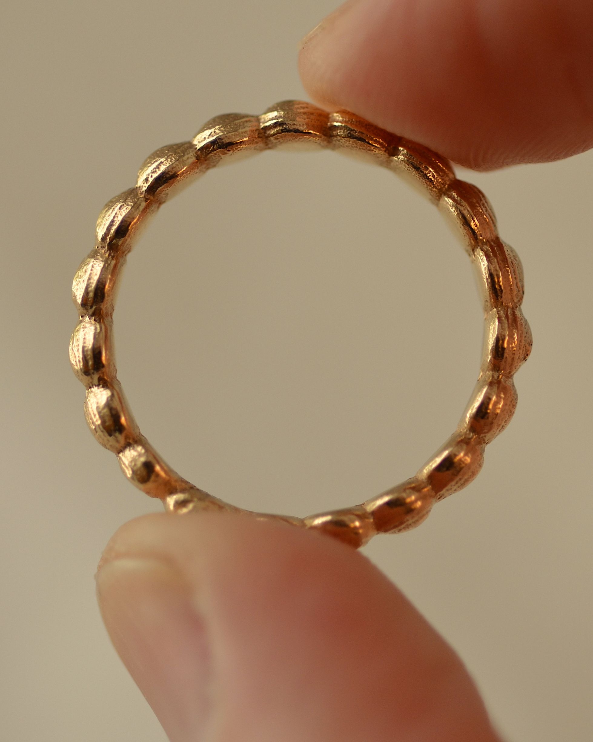 Gold layer ring held between fingers, showing profile