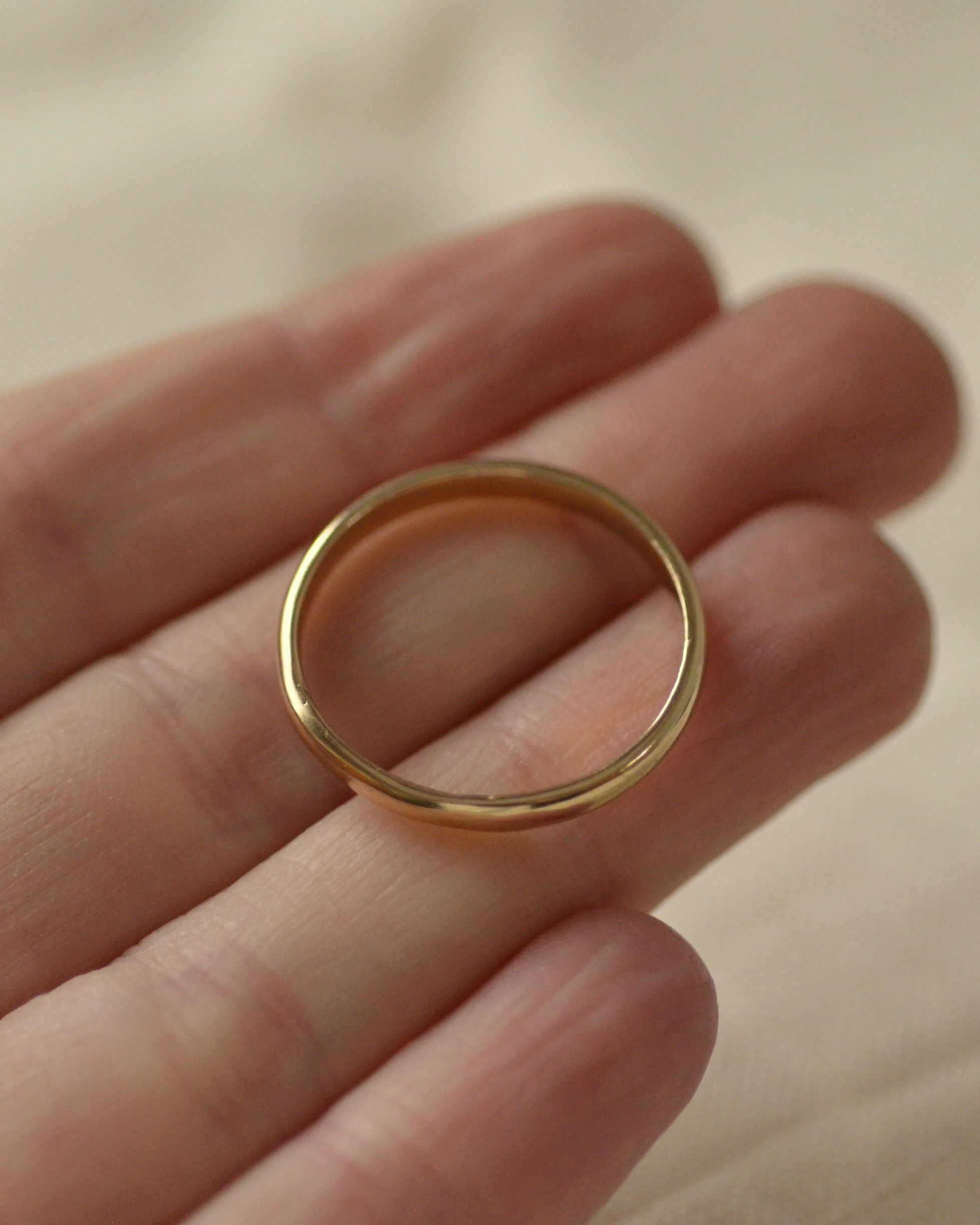 Smooth polished gold ring held in hand