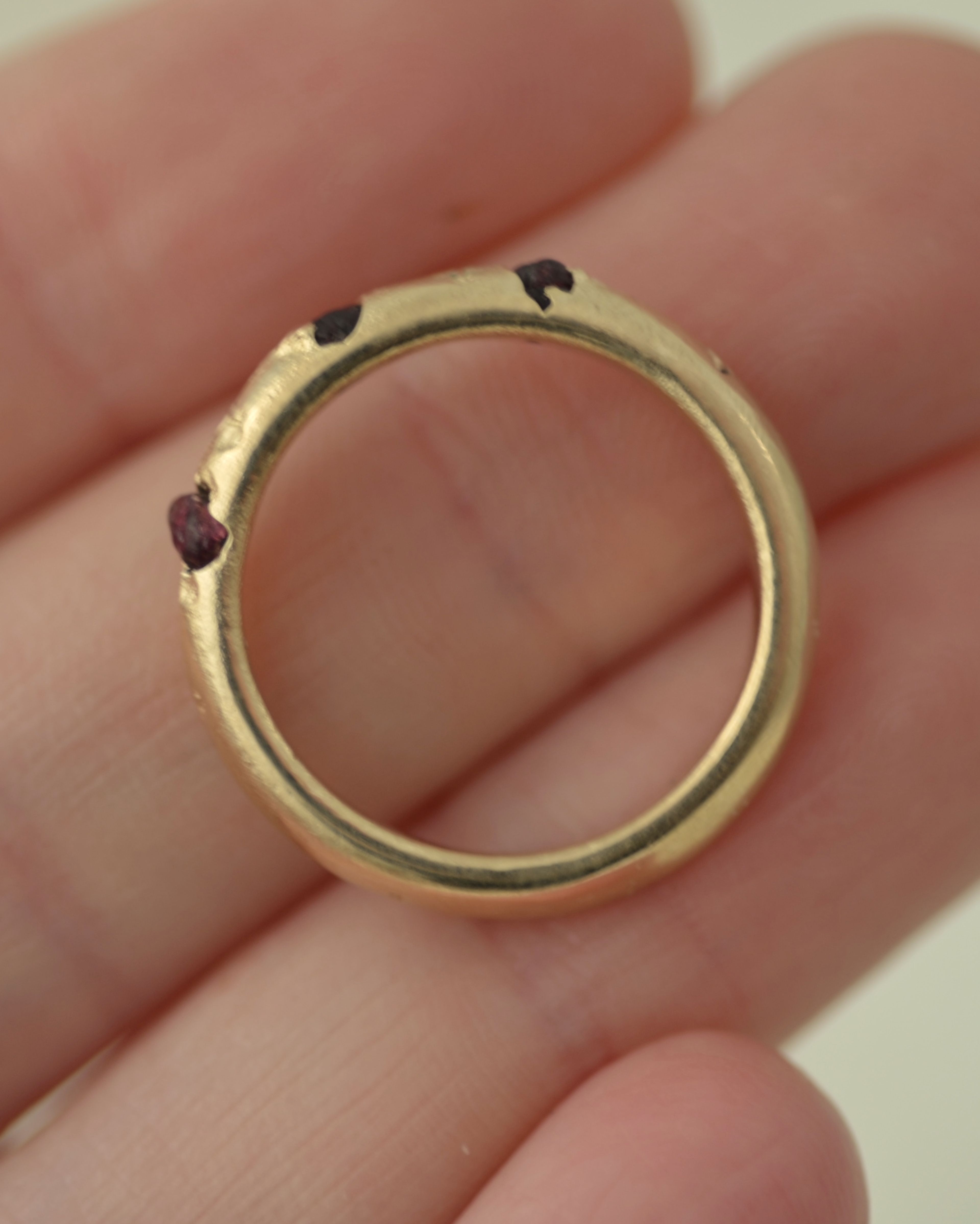 Rough garnet cast in place ring held in hand for scale 