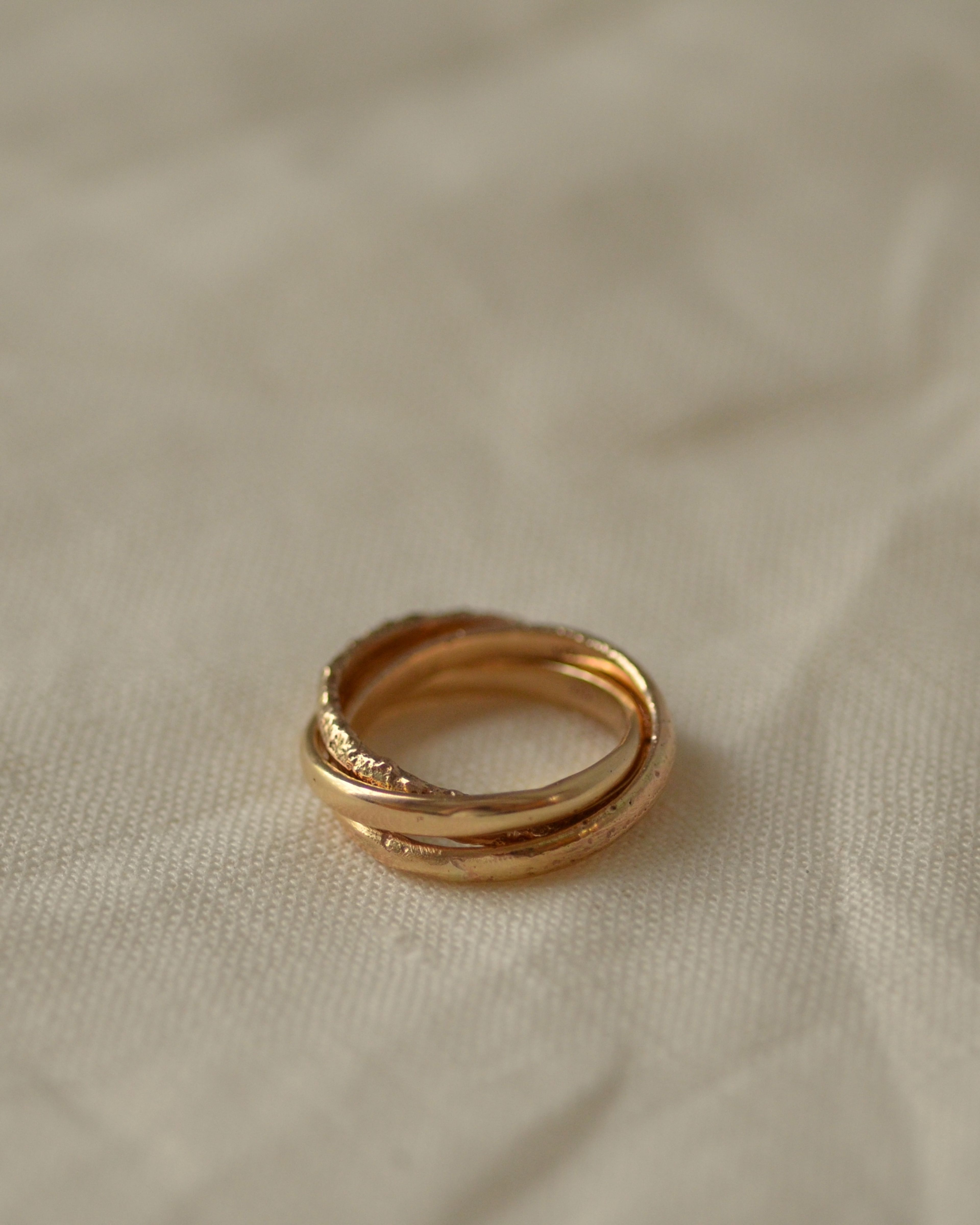 Erosion gold ring on cream linen fabric