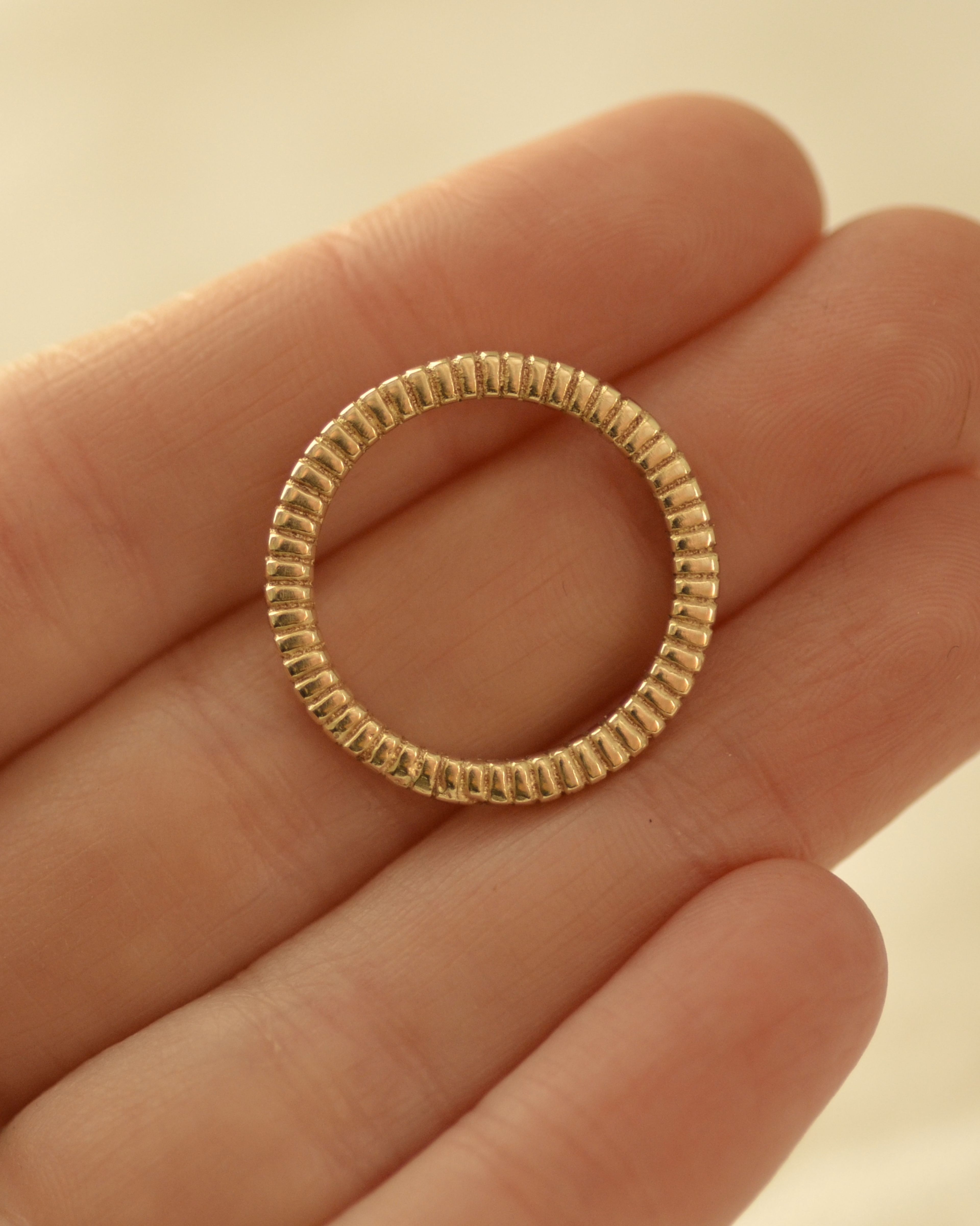 Gold rib ring held in hand showing profile and weight