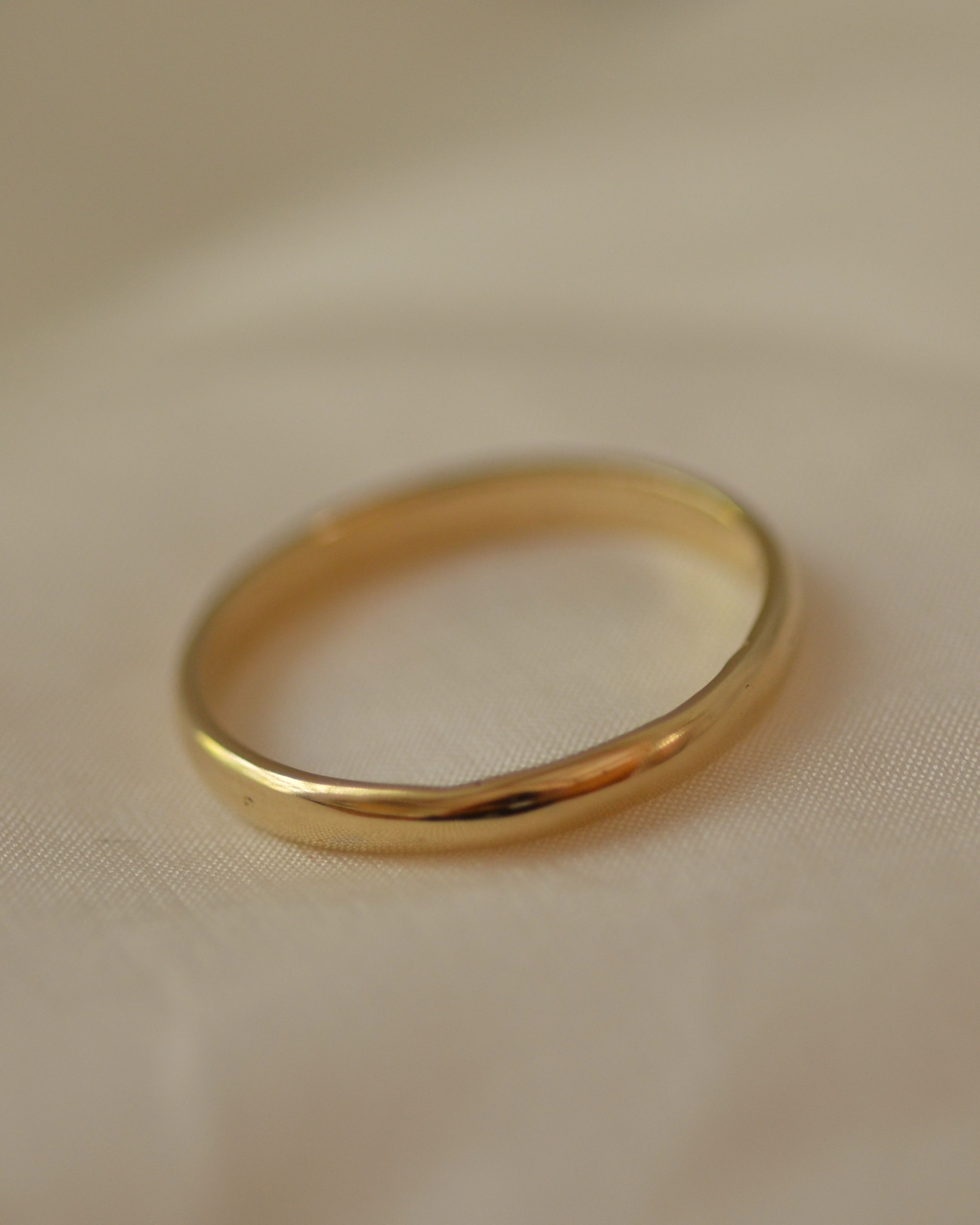 Smooth polished gold band on cream silk