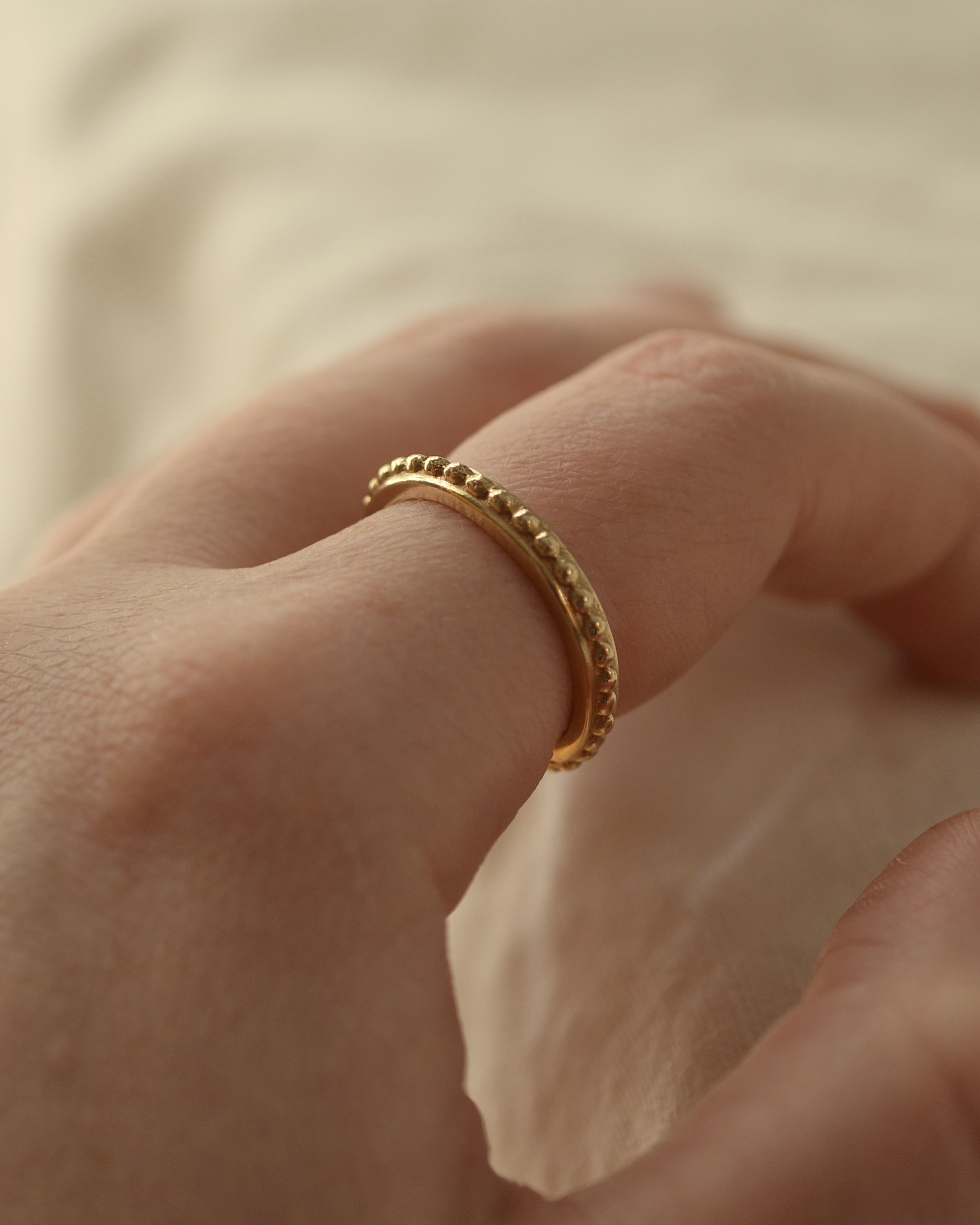 Solid gold grain ring worn on finger