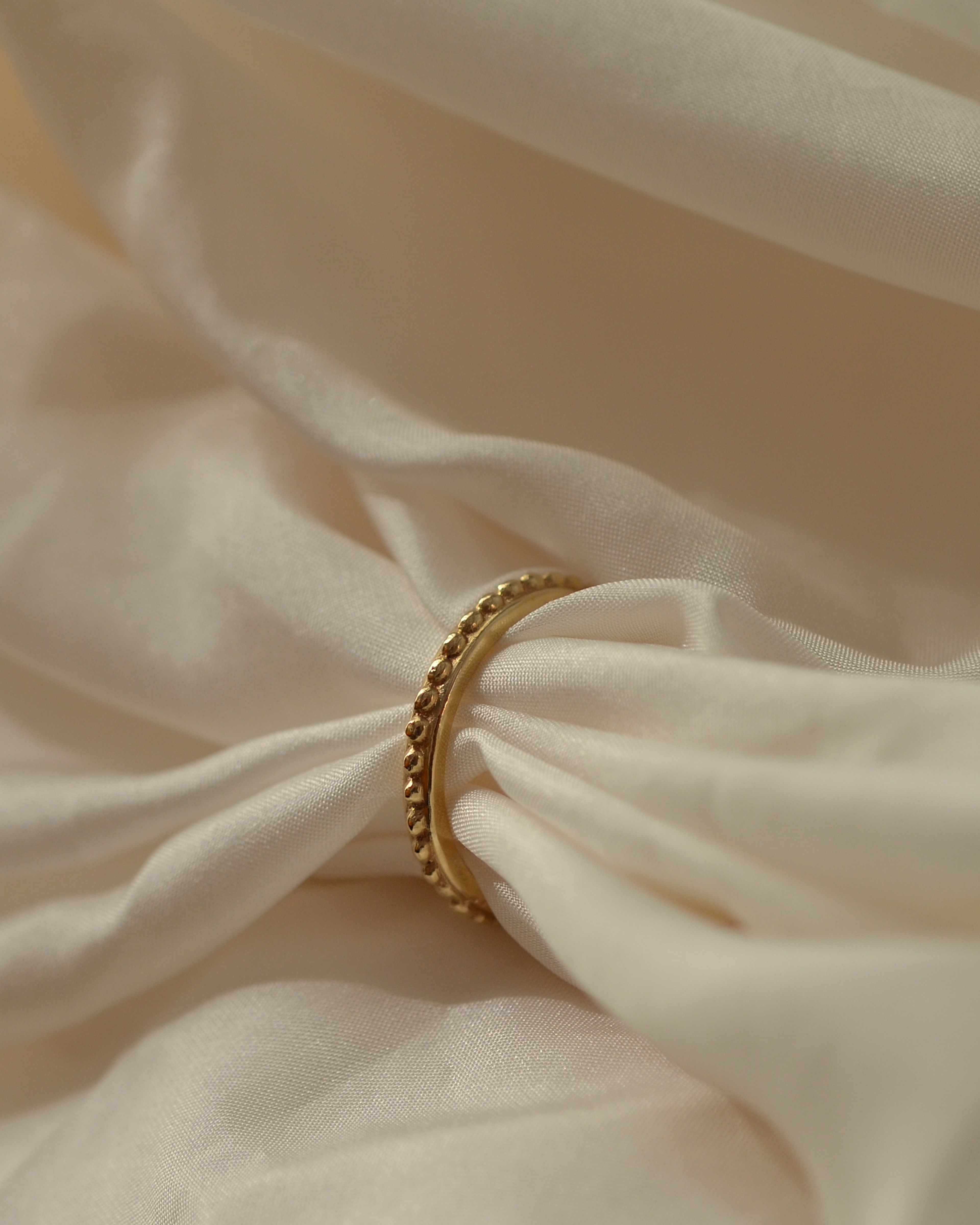 Grain beaded solid gold ring ethical sustainable on cream silk
