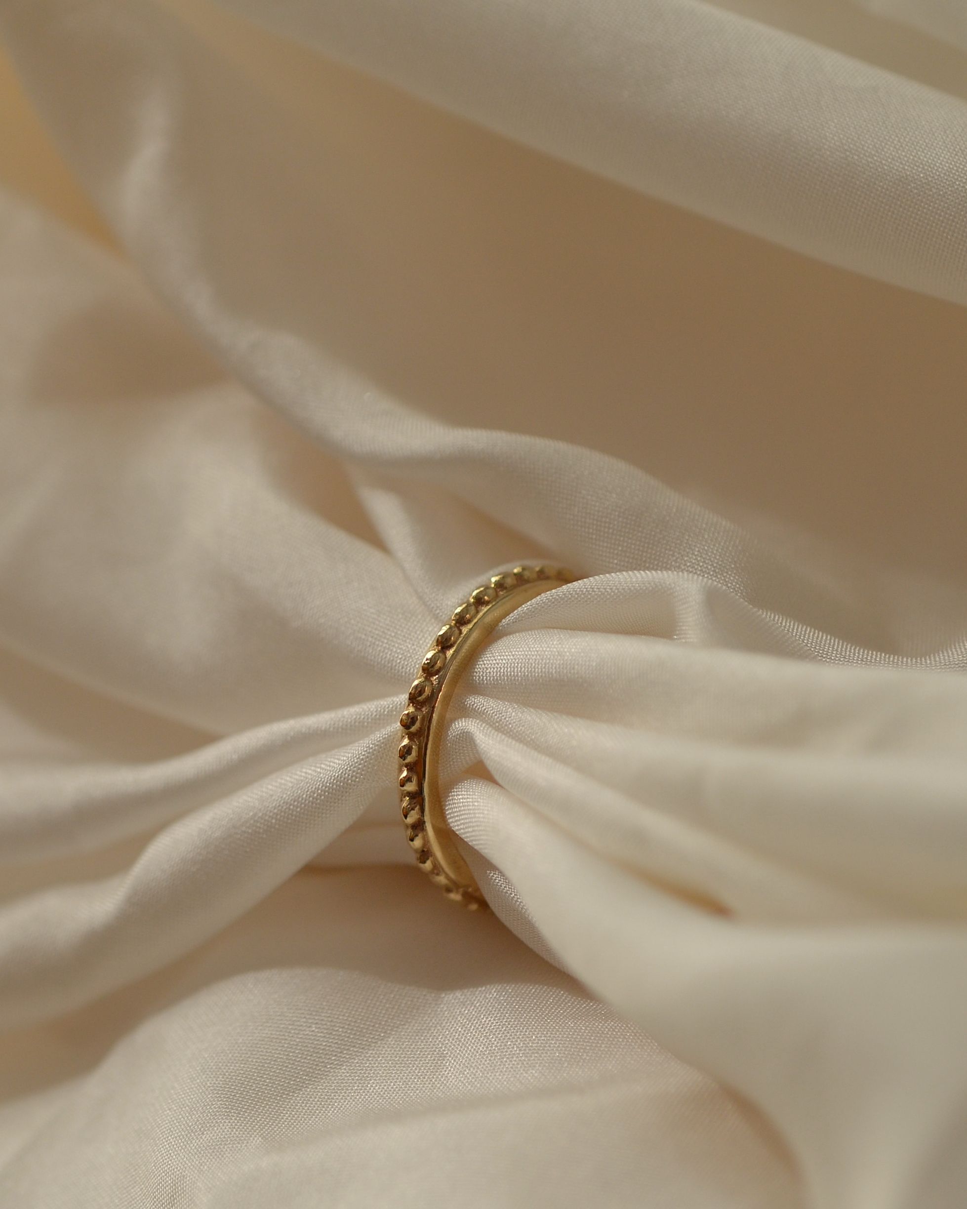 Grain beaded solid gold ring ethical sustainable on cream silk