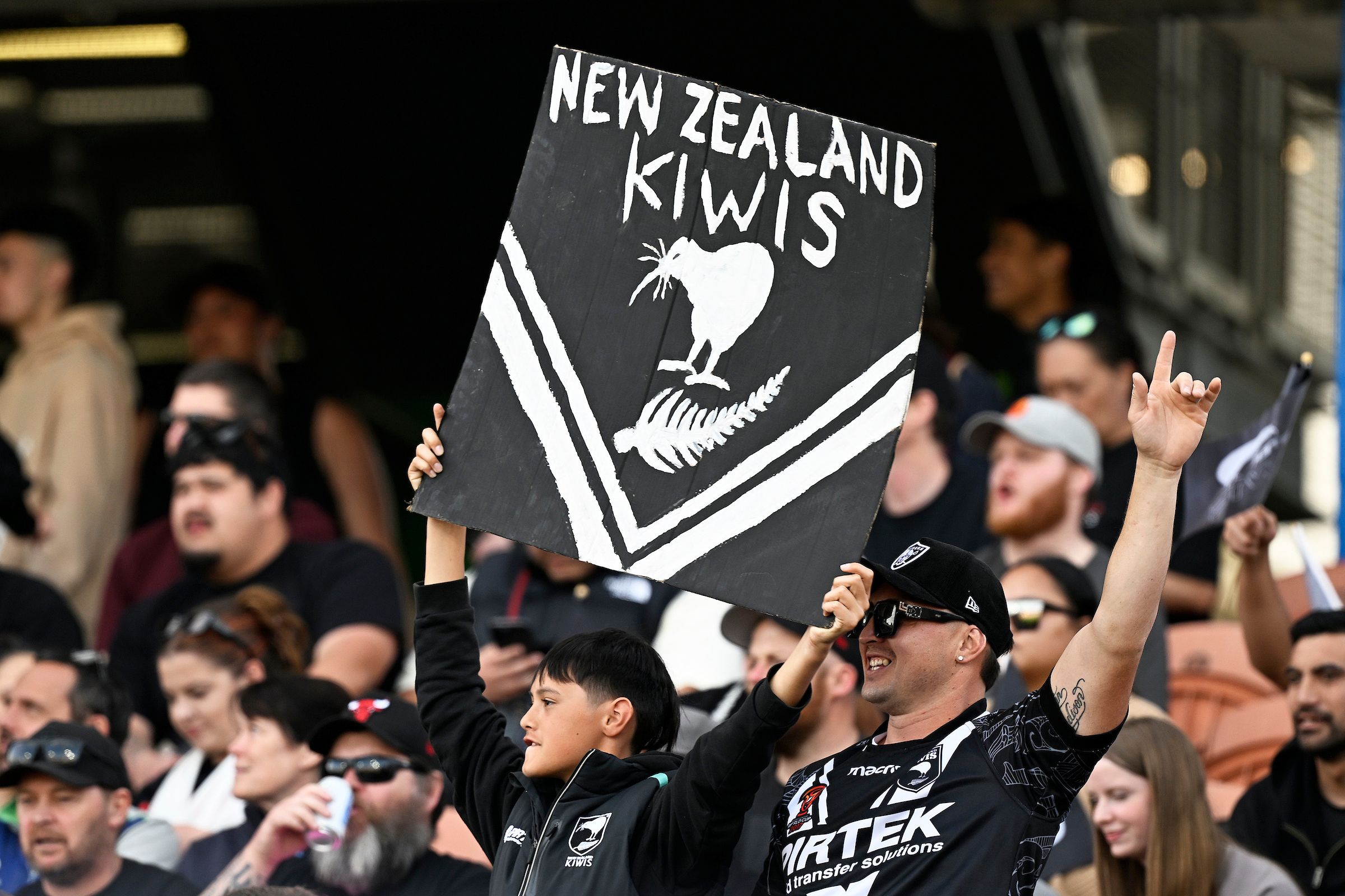 Kiwis fans holding up a banner that says 'New Zealand Kiwis'