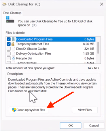 Screenshot of the Windows Disk Cleanup dialog for drive C:, showing file categories to delete and highlighting the ‘Clean up system files’ button at the bottom, indicating where to click to remove additional system files.