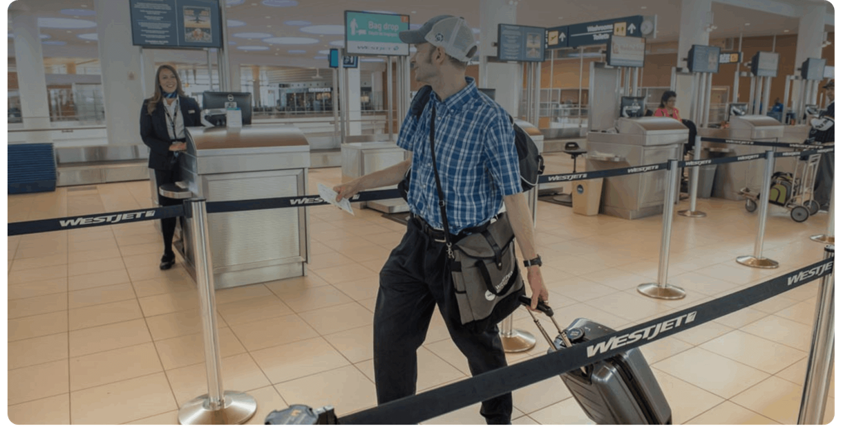 A traveller with a suitcase walks through the check-in area