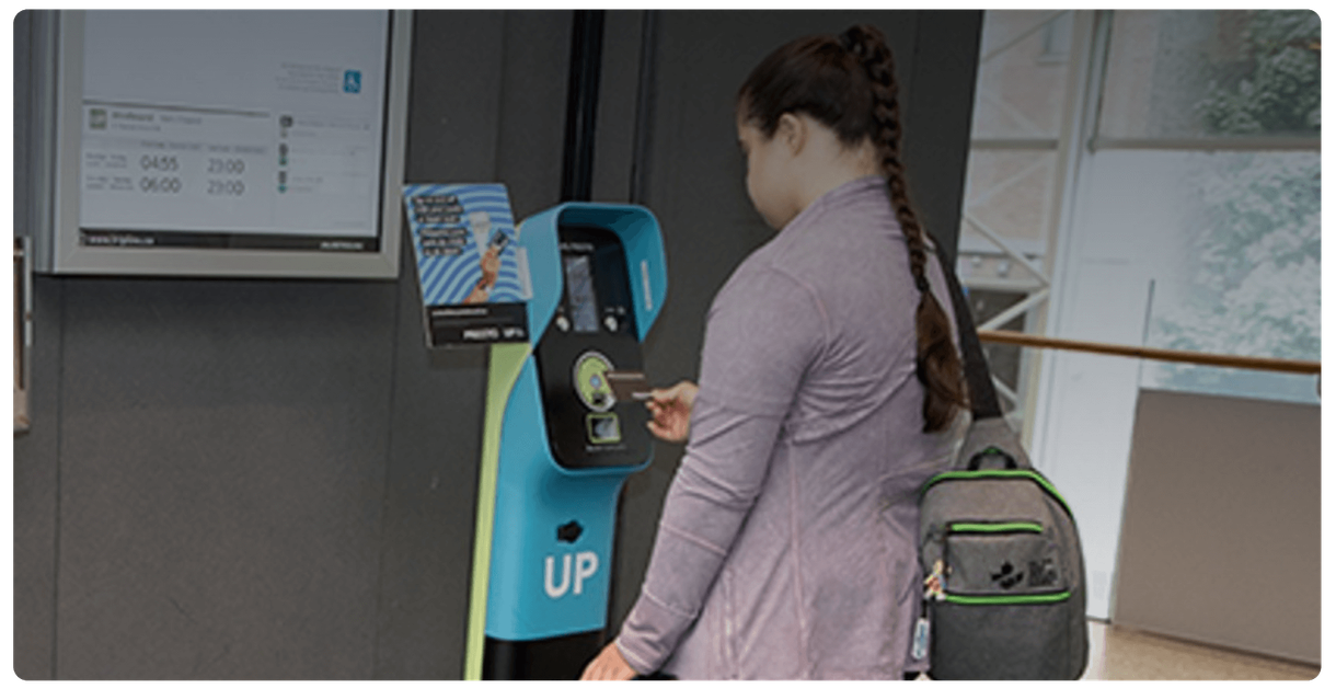 A rider taps a card on a fare reader at an UP Express station