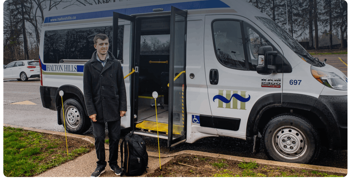 A rider stands beside a Halton Hills ActiVan with its door open