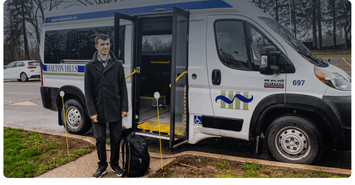 A rider stands beside a Halton Hills ActiVan with its door open