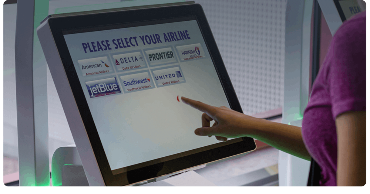 A traveller chooses an airline on a check-in kiosk