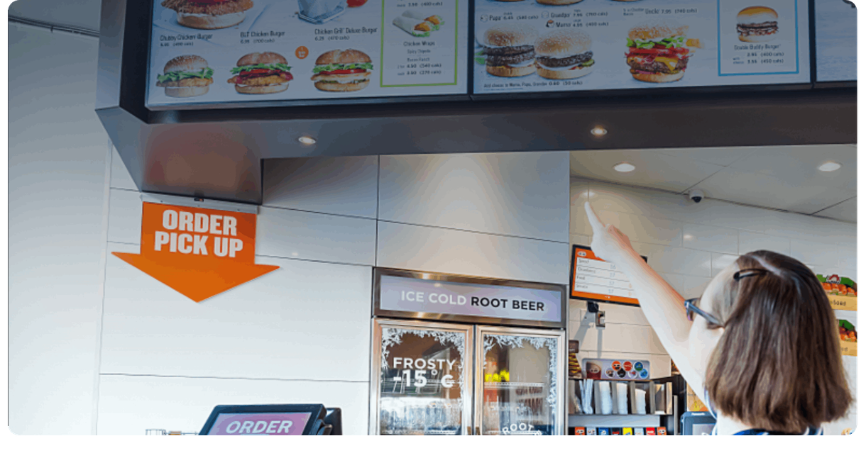 A customer points at the menu board at A&W