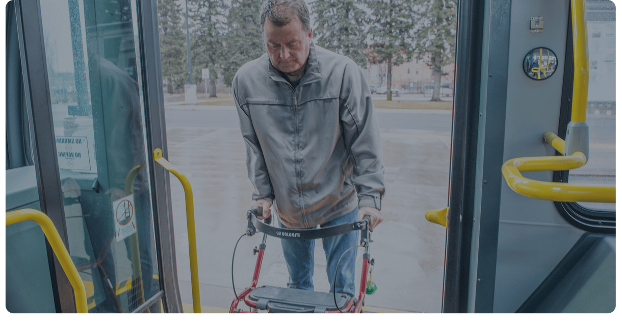 A rider with a walker boards a Stratford Transit bus