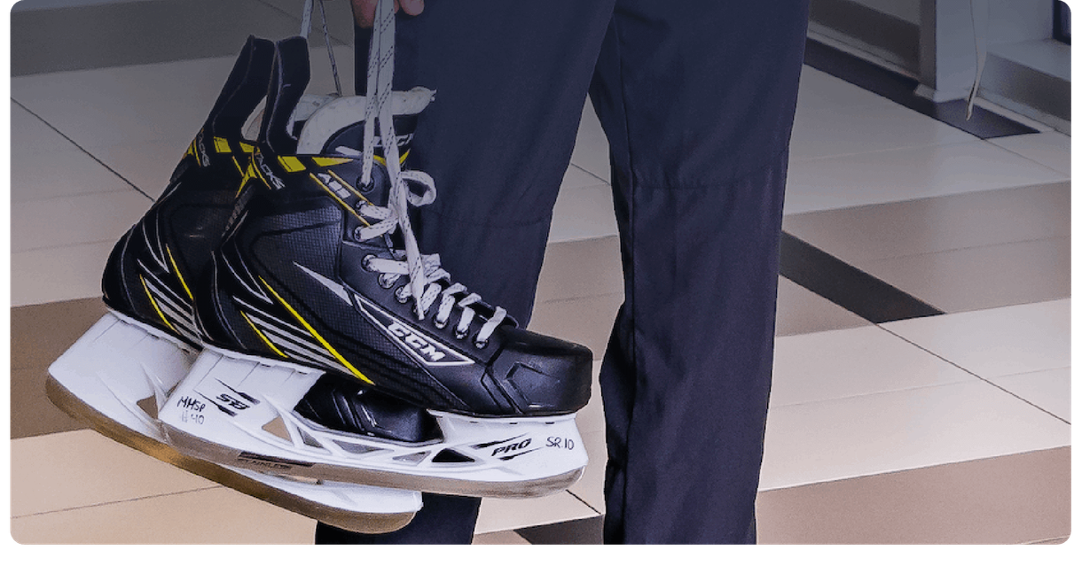 A person carries a pair of hockey skates