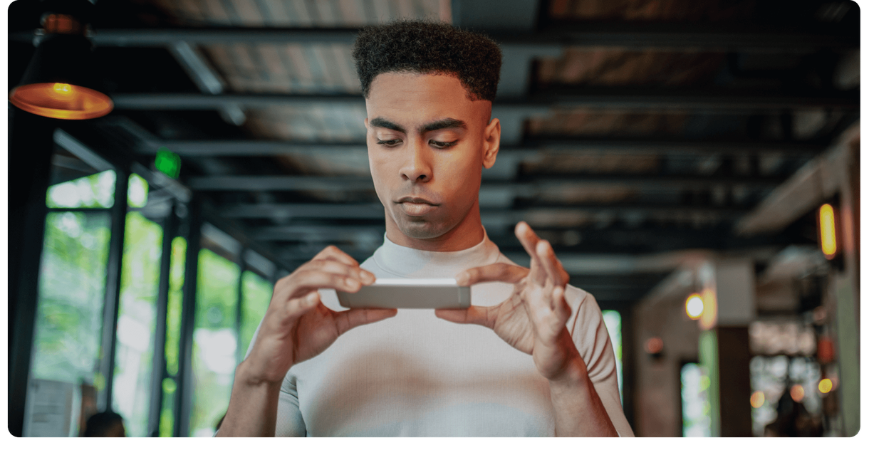 A customer holds a cheque and his phone