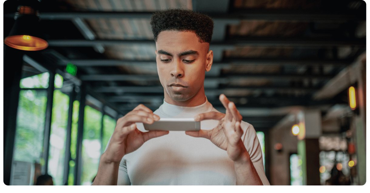 A customer holds a cheque and his phone