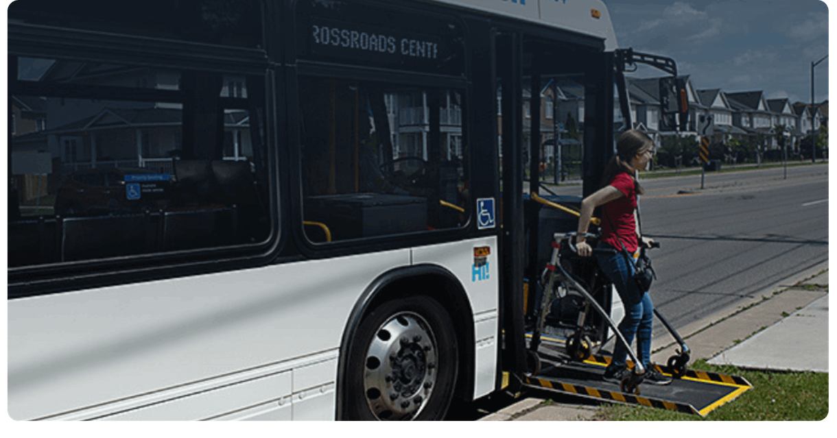 A rider with a walker boards a Milton Transit bus by its ramp