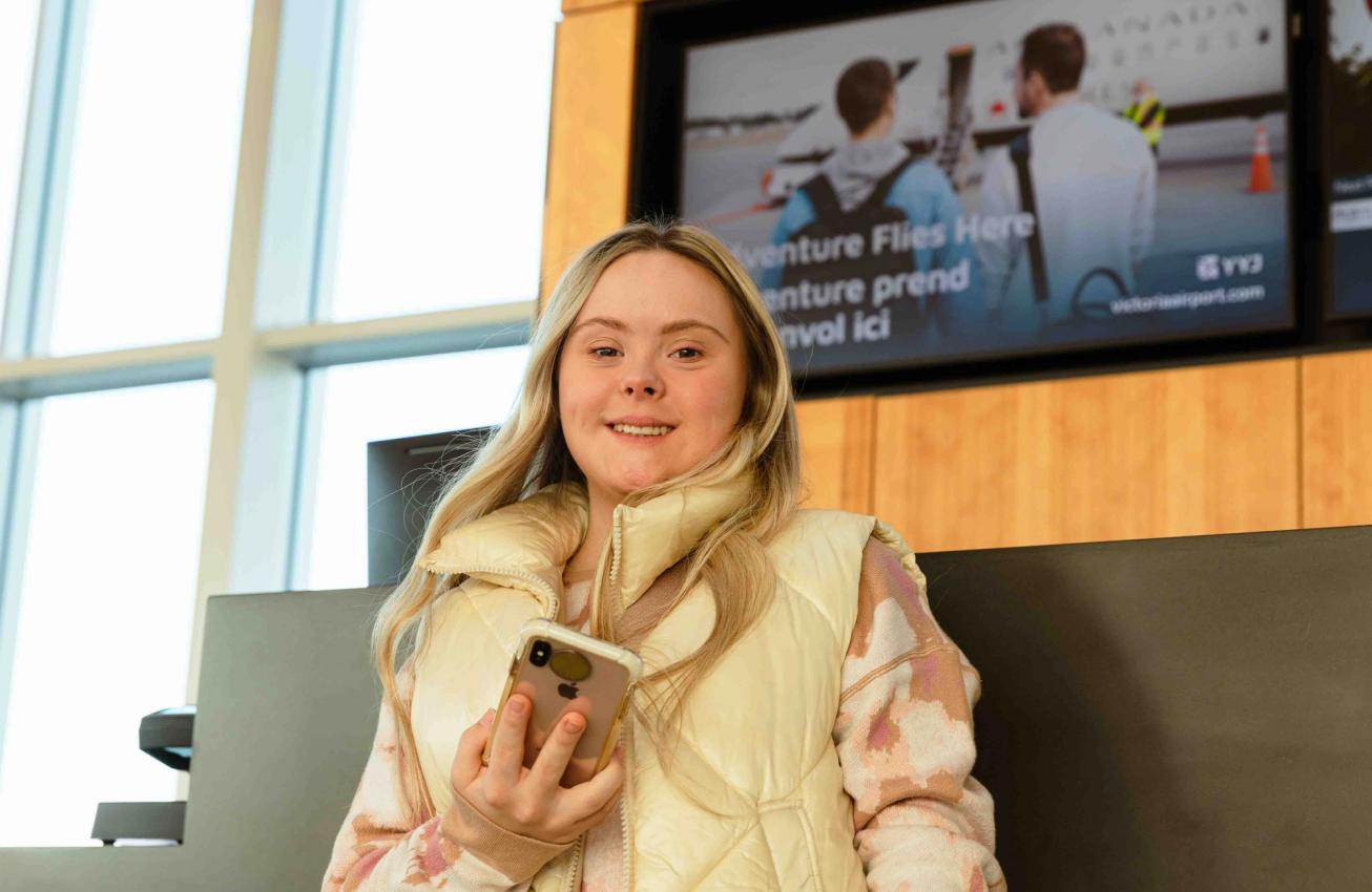 A traveller holds up a phone at Victoria International Airport