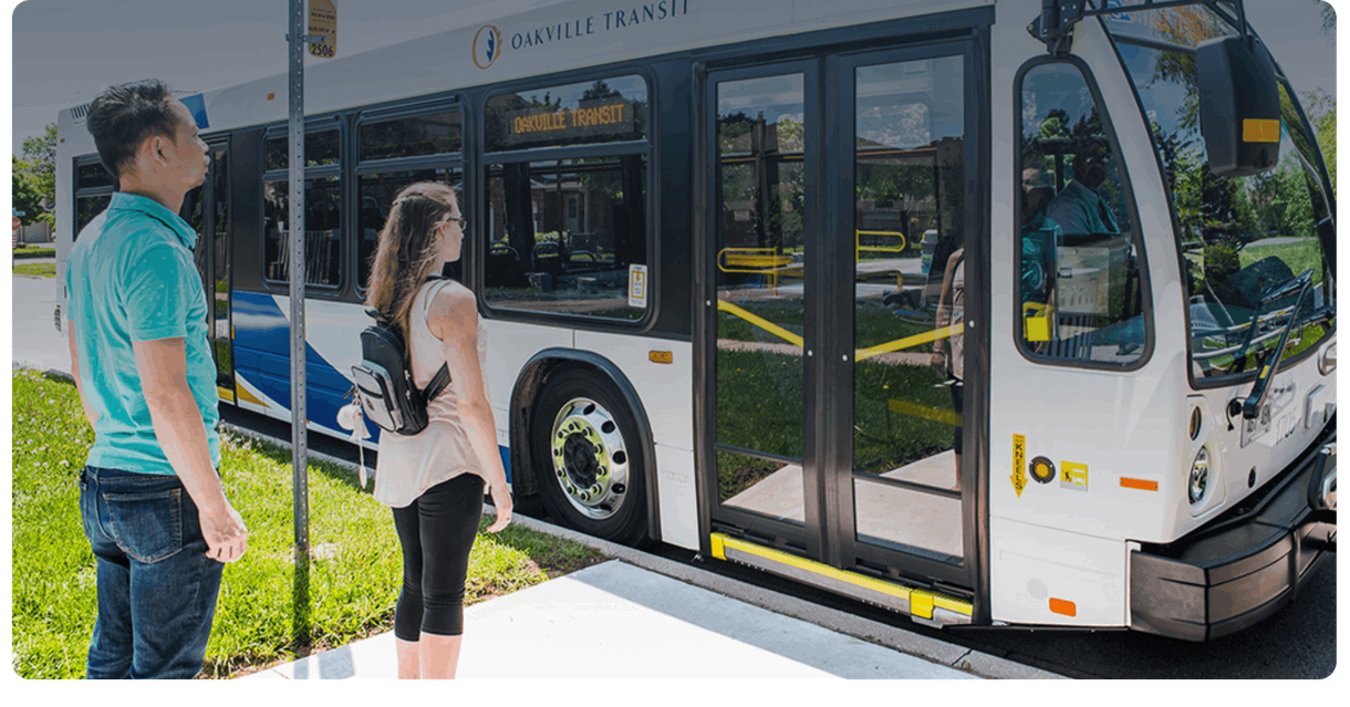 Riders wait at a stop as an Oakville Transit bus arrives