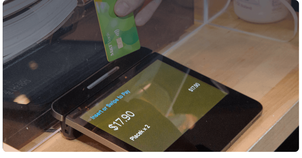 A debit card held over a payment terminal
