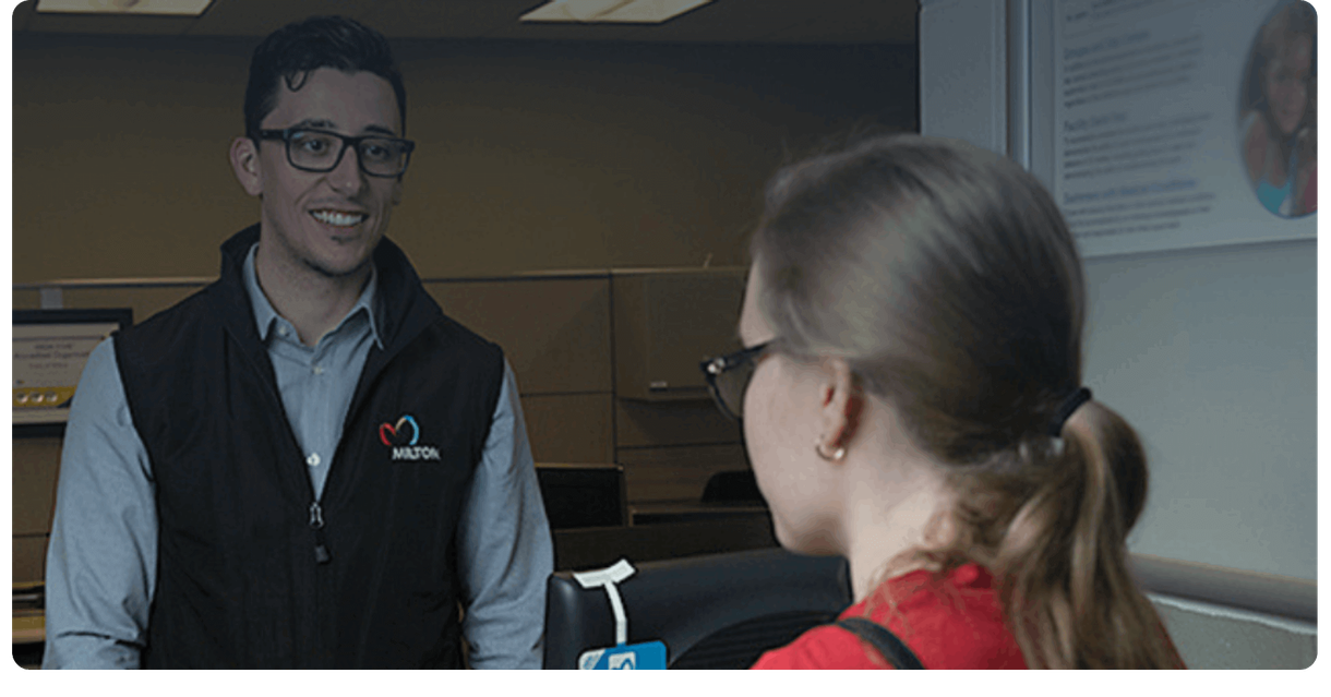 A Milton Transit staff member helps a rider at a service counter