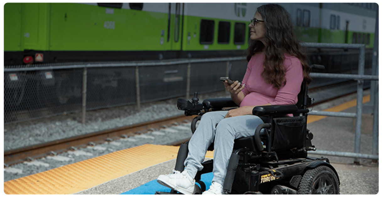 A rider in a power wheelchair waits on a GO train platform