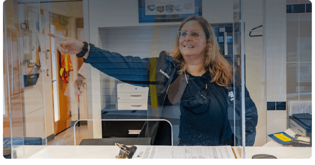 A staff member at the front desk points the way