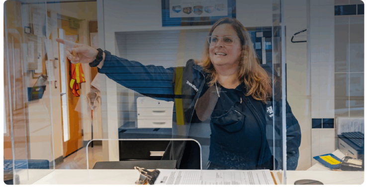 A staff member at the front desk points the way