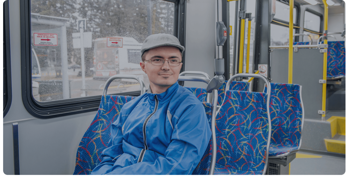 A rider sits in a seat on a Stratford Transit bus