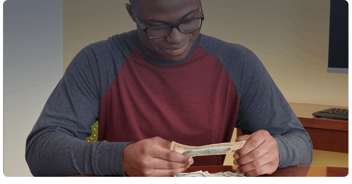 A customer counts cash at a table