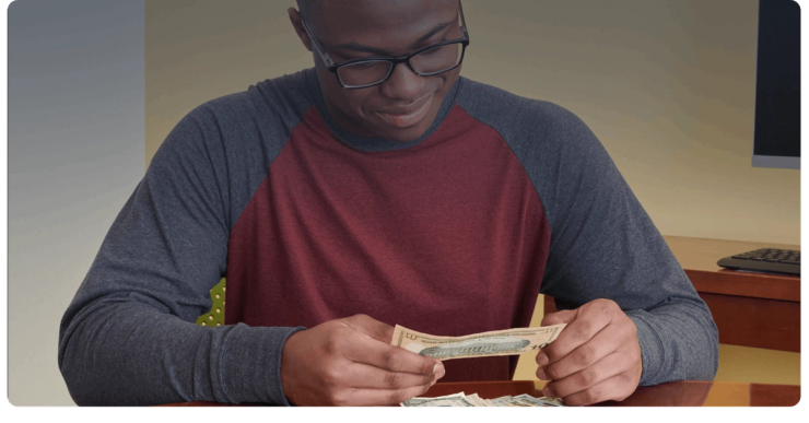 A customer counts cash at a table