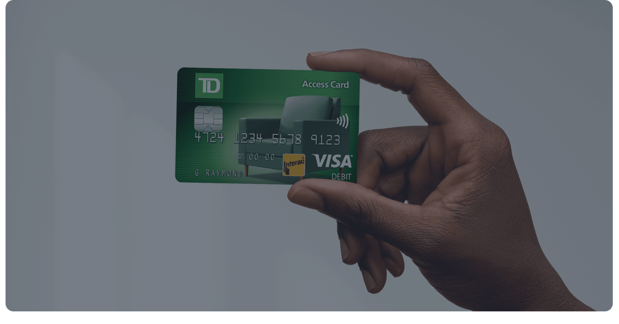 A hand holds up a green TD debit card