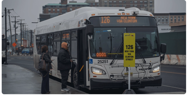 Riders wait to board an NJ TRANSIT bus at a stop